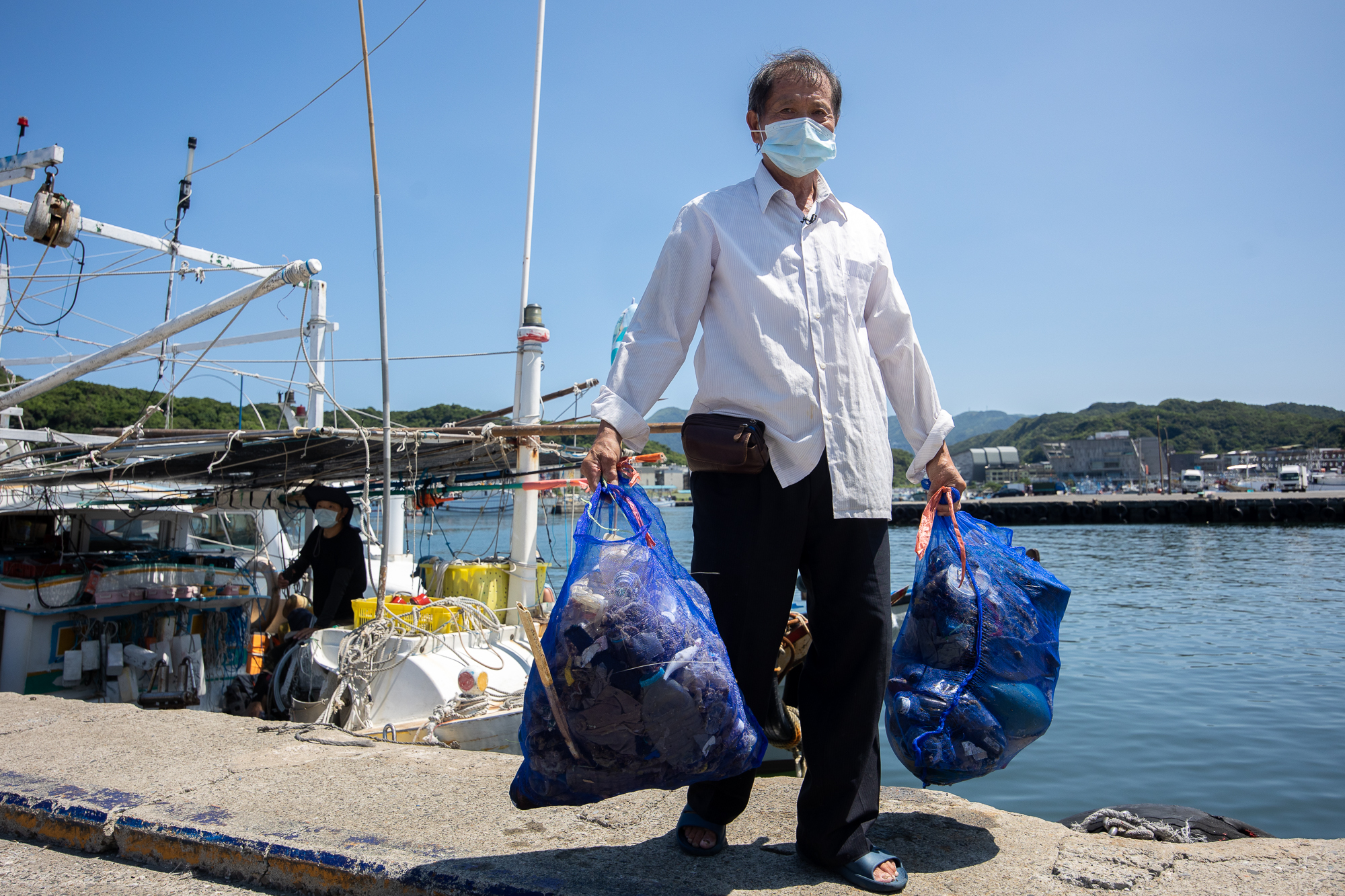 林新永船長拿著海洋垃圾,此次淨海是由他號召25漁船,共35位漁民共襄盛舉。