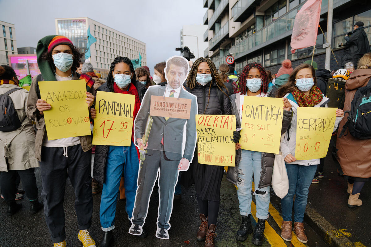 COP26聯合國氣候大會場外，倡議民眾手持巴西環境部長Joaquim Leite的人形立牌，以「巴西沒有環境部長」標語，諷刺巴西政府在會場內試圖以漂綠手段掩蓋亞馬遜森林的破壞程度劇增、原住民的權利驟降。