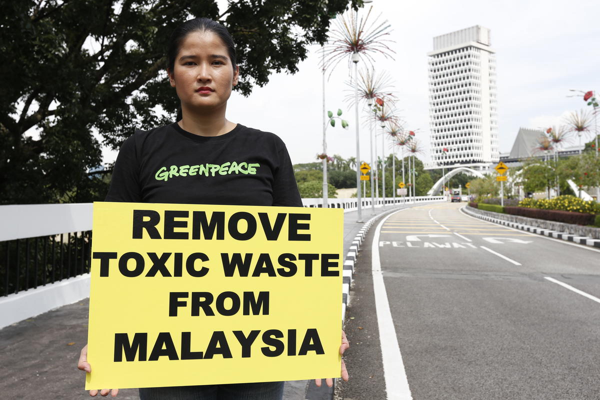 Lee Hui Ling手持寫著「清除馬來西亞有毒廢棄物」的標語，參與綠色和平在吉隆坡馬來西亞國會大廈前的倡議行動。