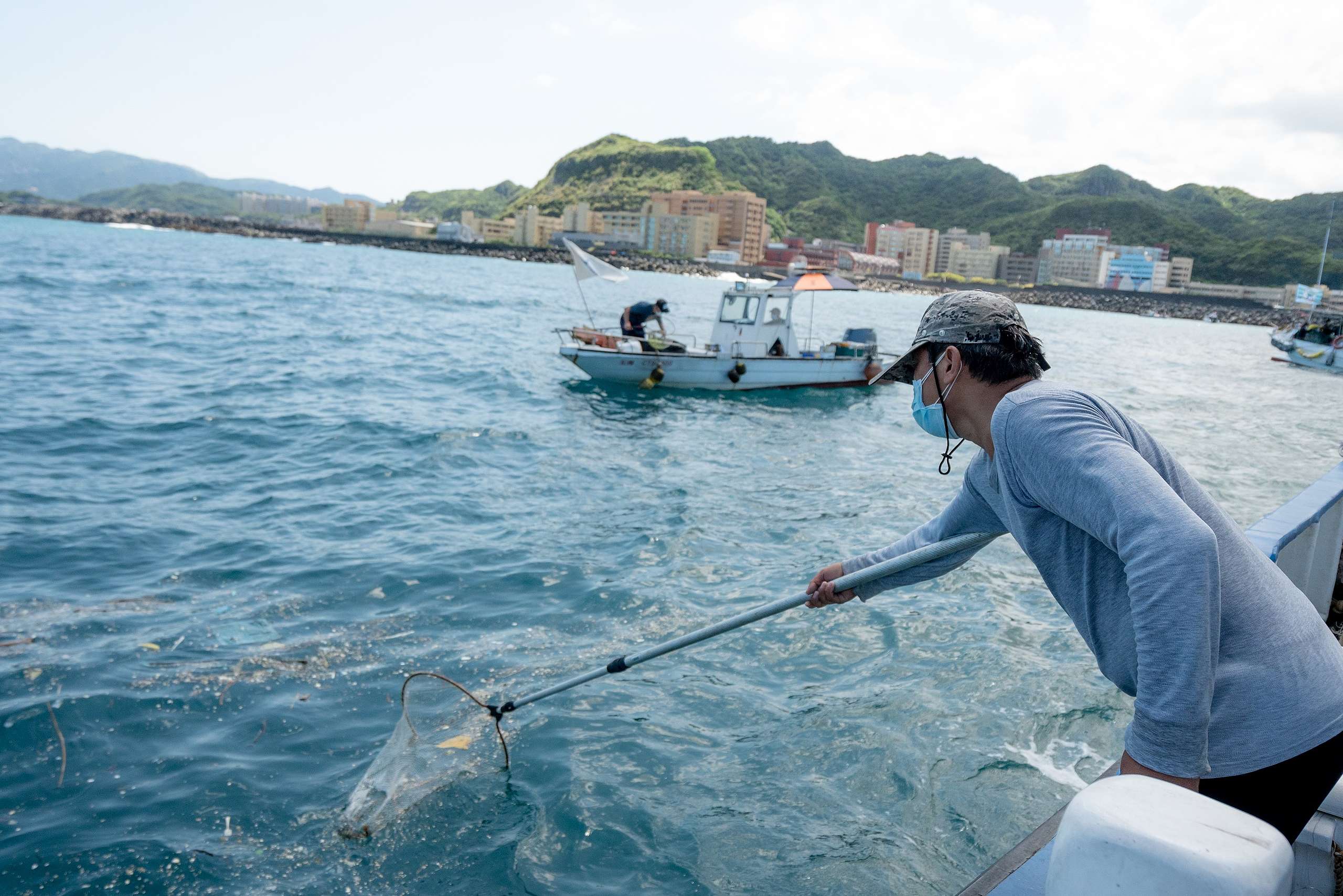 李永泰參與淨海行動,協助將潛水志工清除的海底廢棄物載運上岸,也用撈網把海面上的垃圾帶走。