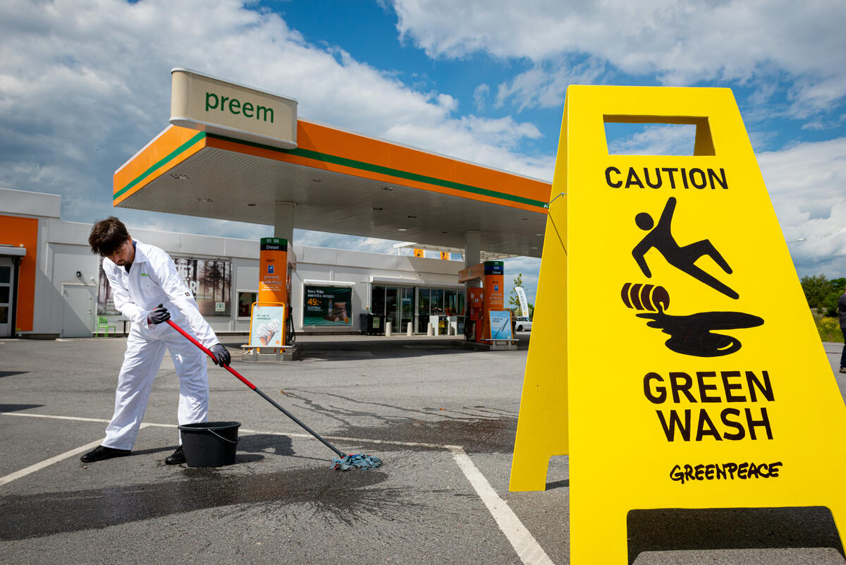 綠色和平行動者在瑞典化石燃料業者Preem的加油站外，以「小心漂綠！」的警示牌，抗議該企業的煉油廠擴展計畫。