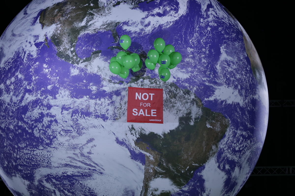 2021年COP26會議結束前夕，綠色和平行動者於會場內徐徐升起「地球不是非賣品」布條，促請世界領導人優先保障人民與環境福祉。