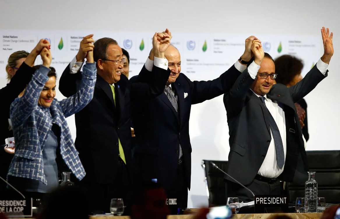 2015年12月12日，法國總統（右起）、COP21主席、聯合國氣候部長、聯合國秘書長舉起雙手，歡慶通過《巴黎協定》。
