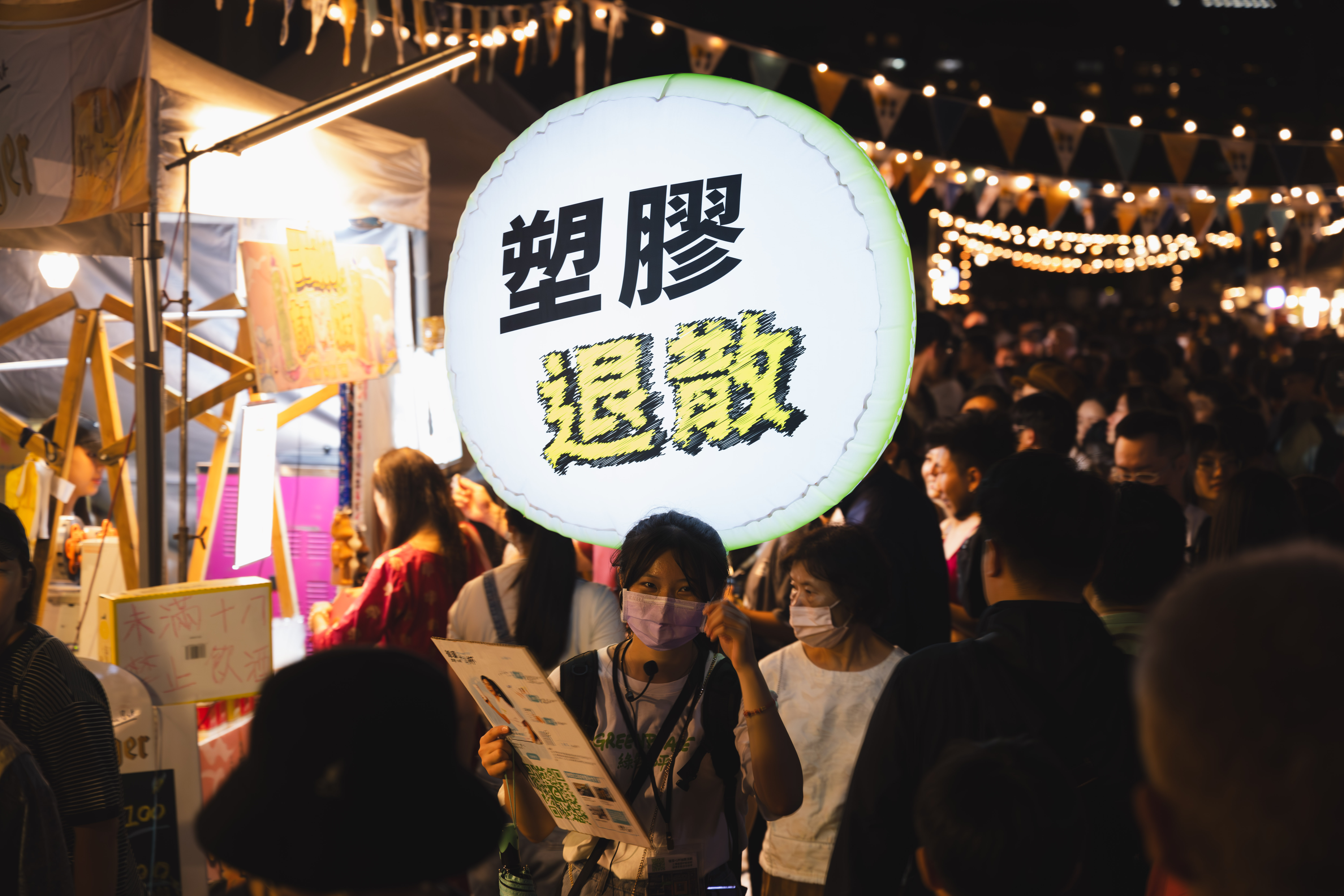 綠色和平志工戴上小蜜蜂、背上顯眼的發光裝置穿梭「2023年臺北白晝之夜」的餐飲市集，宣導租借循環容器。