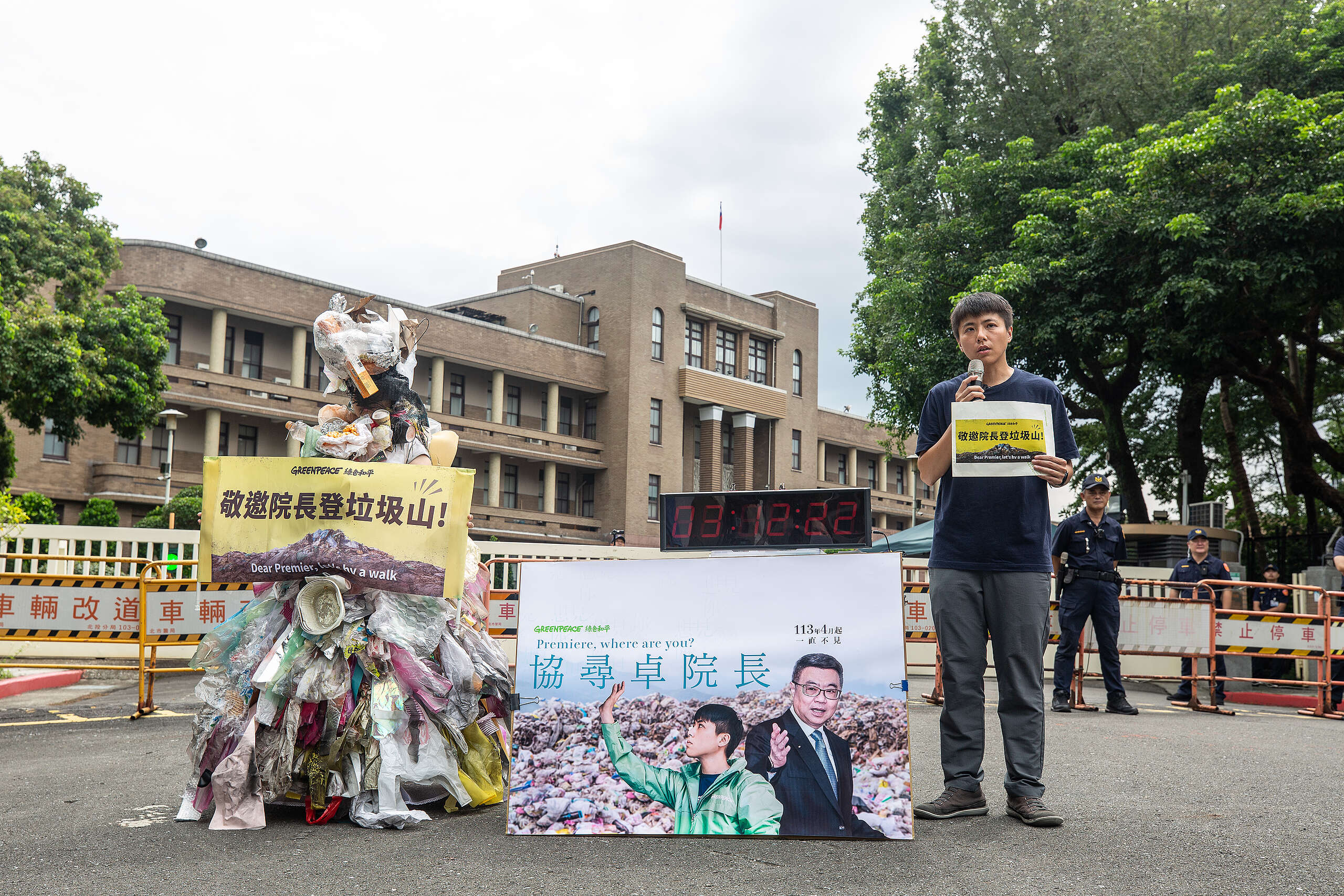 2024年8月15日,綠色和平減塑專案主任張凱婷(右)與扮成垃圾人的行動者(左)清晨 5 點駐守於行政院外,邀請卓榮泰院長親赴垃圾山。