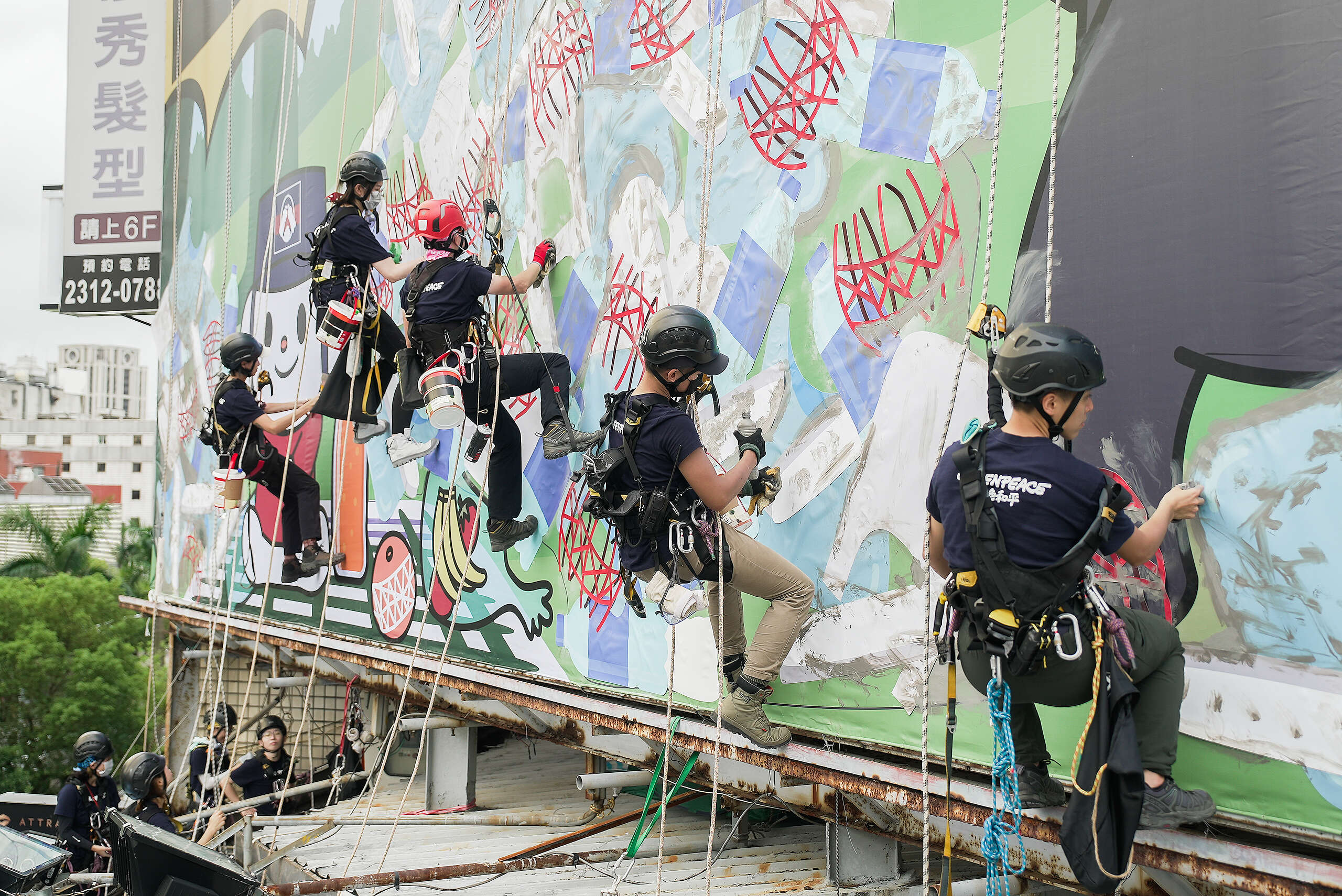 綠色和平出動22名行動者，於西門町鬧區進行巨型看板創作，揭露全聯每年製造至少1億個塑膠包裝，進一步危害野生動物。