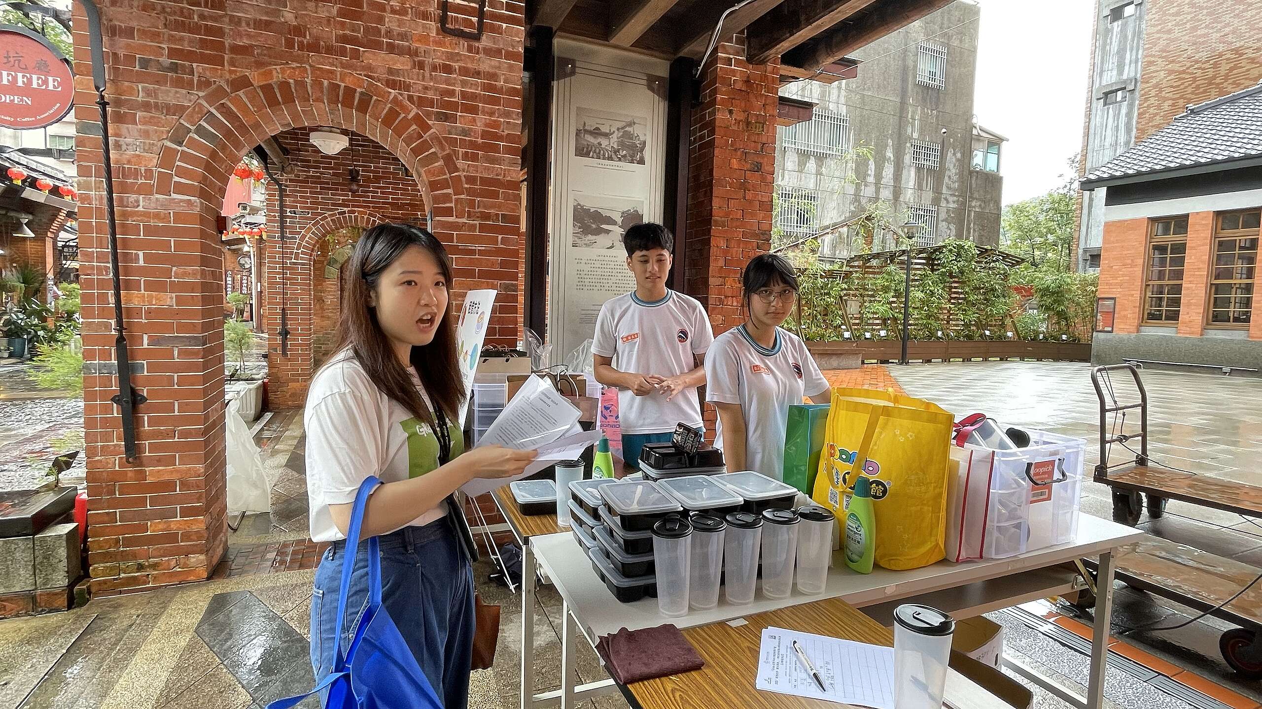 綠色和平受邀前往深坑老街,體驗並記錄循環餐具租借活動。學生們在攤位上整齊擺放餐盒與飲料杯,等待遊客前來租借。