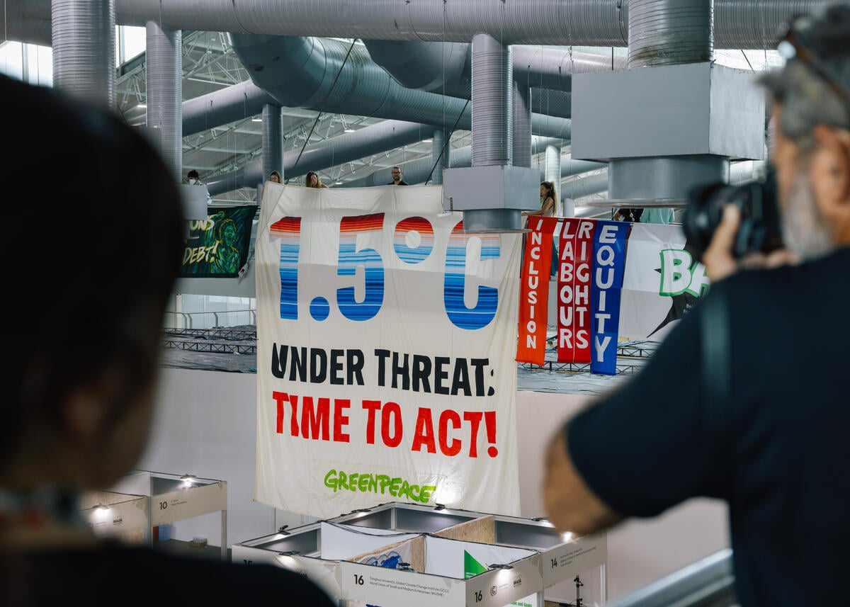 綠色和平與盟友一同在 COP30 會場展開布條，上面寫著：「1.5°C 面臨威脅，是時候採取行動！」