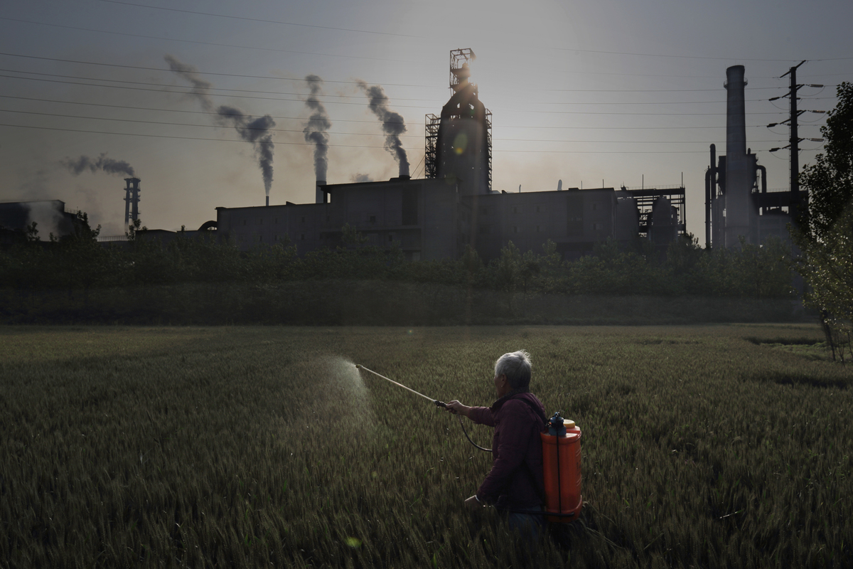 Spraying Crops in front of Steel Plant in Jiangsu. © Lu Guang / Greenpeace