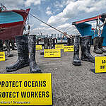 Greenpeace Indonesia holds a photo-op “Boots to boost justice” using fishers' boots in Muara Baru fishery port, North Jakarta.