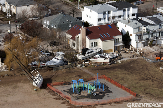 A cleaned up playground in the foreground is ready for children while boats are still piled up against houses in this Staten Island neighborhood