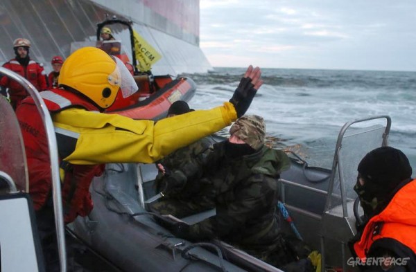 A Russian Coast guard officer is seen pointing a knife at a Greenpeace International activist