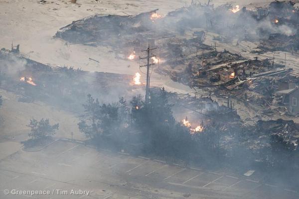 An aerial view of a burnt out neighborhood with open natural gas fires from pipes that broke in damaged buildings during Hurricane Sandy.