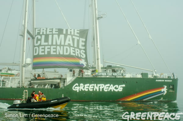 The Rainbow Warrior, Greenpeace's iconic flagship, sails alongside an inflatable as she arrives in San Francisco