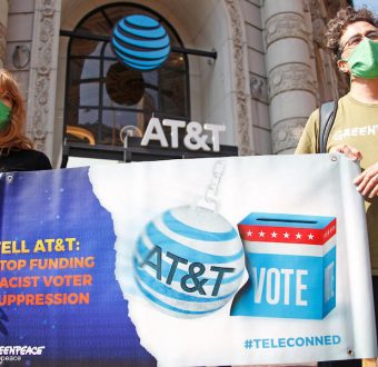 Photo: Greenpeace US activists demand AT&T (an American multinational conglomerate holding company) not wreck our democracy by funding racist voter suppression. The activists pass out flyers calling on AT&T to stop funding extremist politicians who sponsor racist voter suppression bills. Two activists are dressed in cell phone costumes playing an AT&T video.