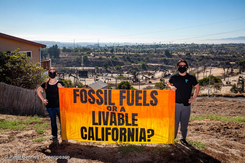 Photo of Greenpeace US banner reading "Fossil Fuels or a Livable California?"