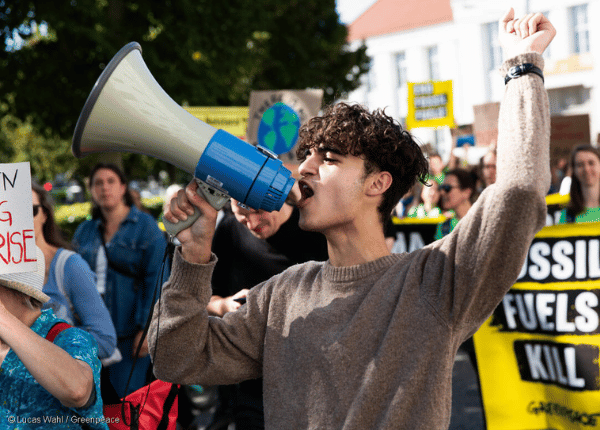 Activist uses a megaphone at a protest against fossil fuels.